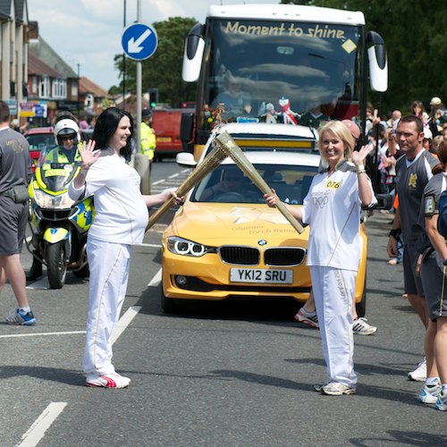 Anita Adams gives the flame to Kathryn Pridmore