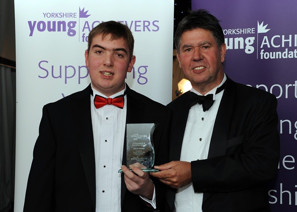 Elliott Marks receives the Achievement in Education Award from Martin Penny