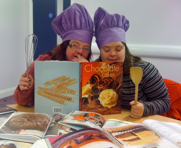 Two of the Purple Patch Arts fundraisers, Emily Moorhouse (from Huddersfield) and Felicity Bagley (from Harrogate) look for recipe inspiration at Harrogate Library