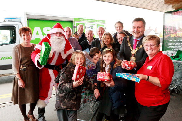 Christmas cheer. Santa is greeted by  the Mayor of Harrogate Councillor Michael Newby, children from Grove Road School, members of staff of Asda, and representatives of Harrogate Brigantes’ Rotary Club, Yorkshire Air Ambulance and  Wellspring Therapy and Training