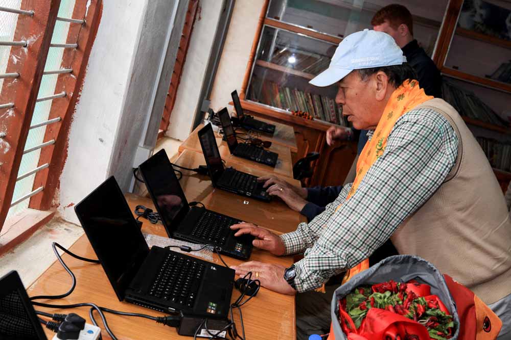 Nepalese Rotarian Major Lil Gurung MBE of the Rotary Club of the Himalayan Gurkhas (Kathmandu) helps to set up the new computer equipment at Shree Jana Higher Secondary School, Rapakot