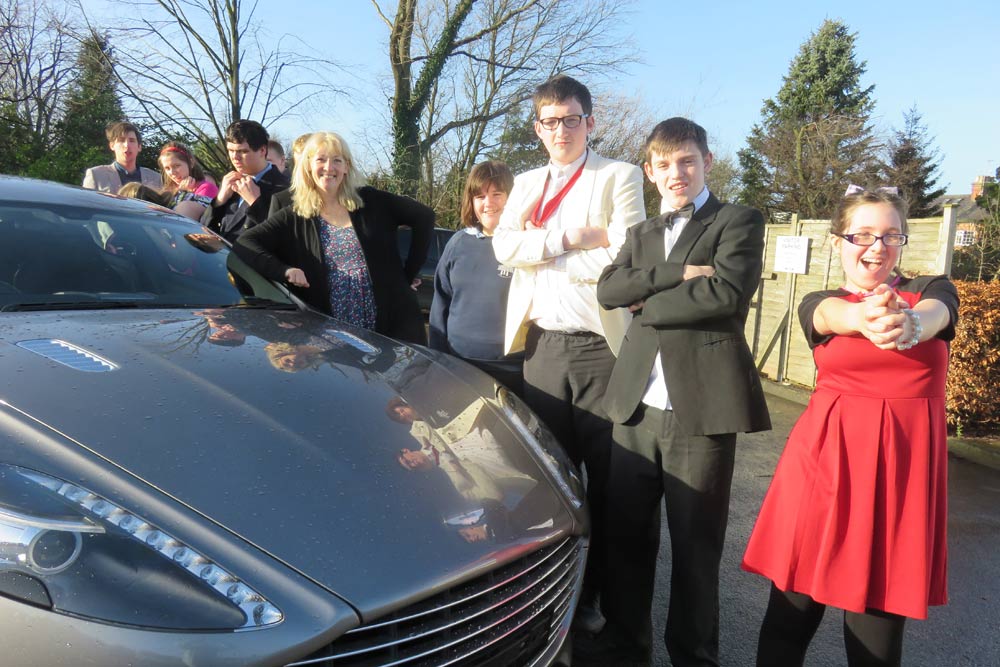 Helen Stewart Smith (centre) and pupils of Forest School pose for a photoshoot with the Aston Martin