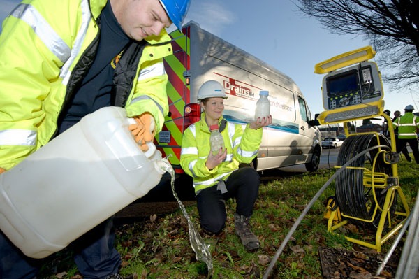 Fat busting bugs being added to a sewer via a manhole