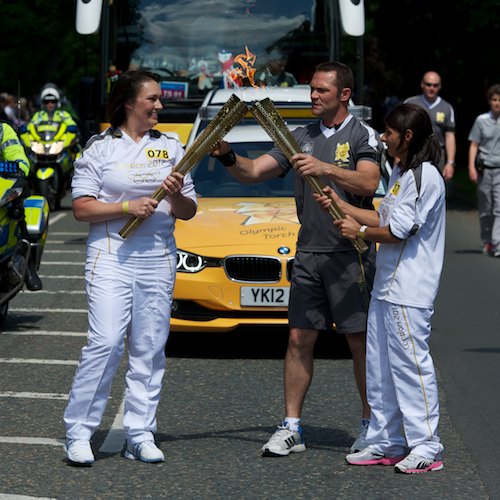 Kelime Cetinkaya receives the flame from Helen Mackenzie