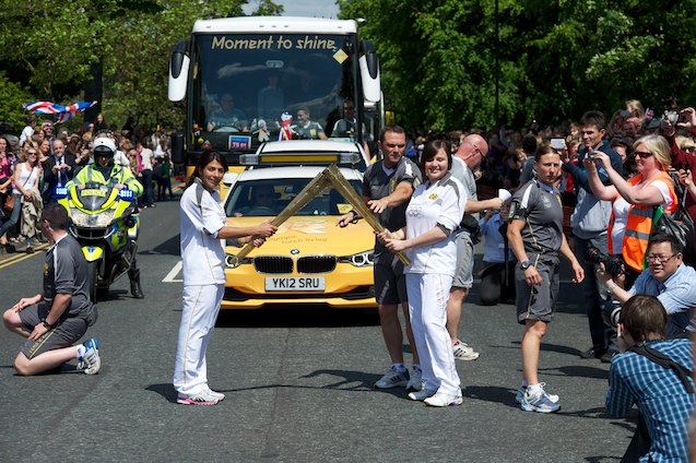 Kelime Cetinkaya gives the flame to Caitlin Chang