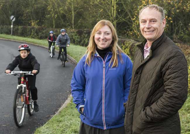 County Councillor Dadd with class teacher Gemma Goodchild and children from Husthwaite Primary School enjoying the newly resurfaced and now pothole-free road outside the school for their cycling proficiency training