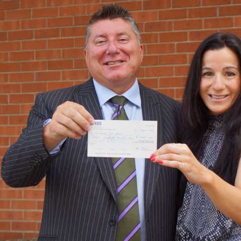 Winning Ticket! Stephen Outhwaite from Outhwaite Associates presents the “winnings” from a day at the races to Christina Demetriou from Caudwell Children 