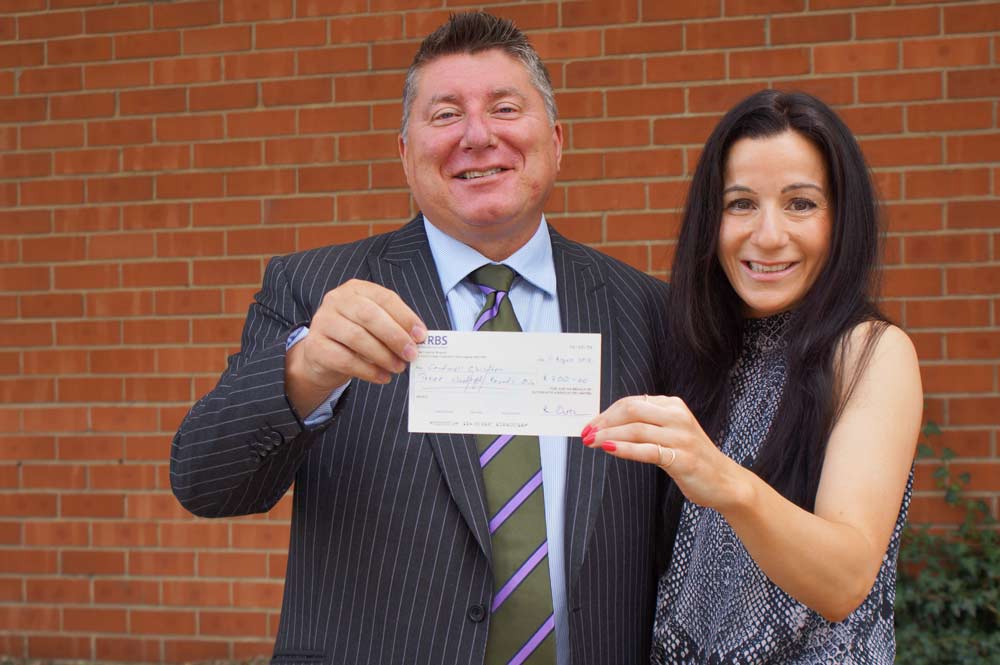 Winning Ticket! Stephen Outhwaite from Outhwaite Associates presents the “winnings” from a day at the races to Christina Demetriou from Caudwell Children 
