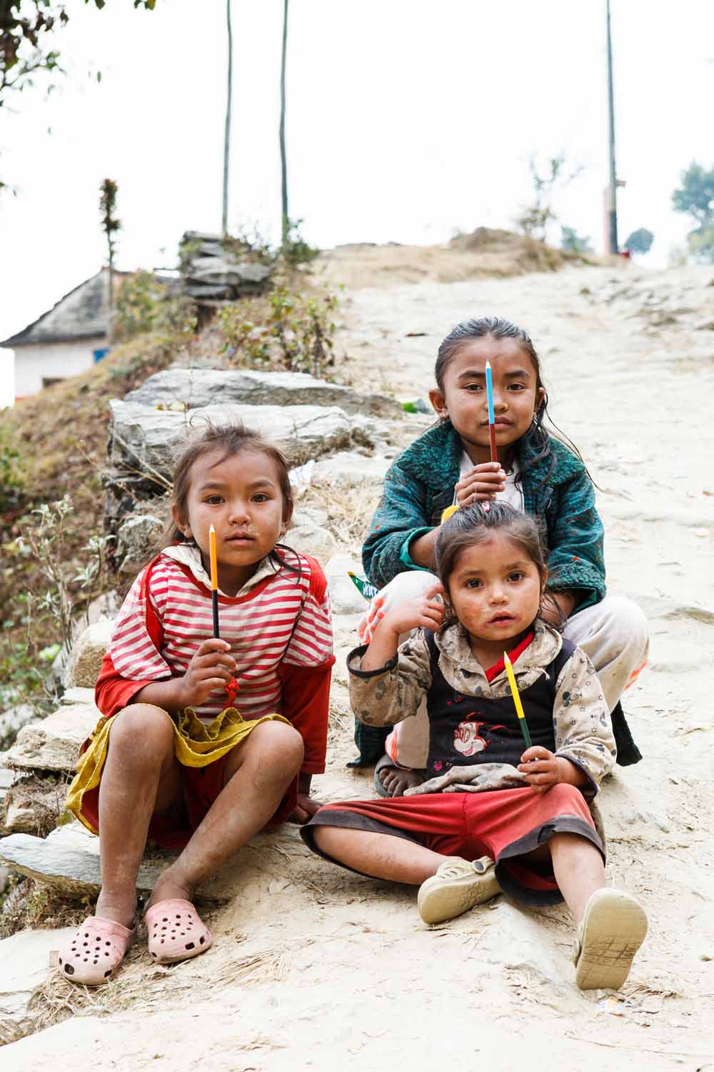 Local children proudly show off their new pencils, Panchamul Valley