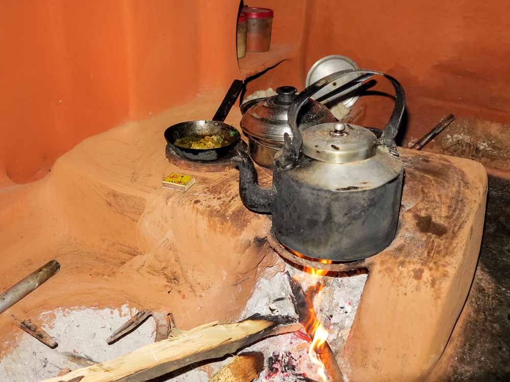 Many of the villagers still cook on open fires in the kitchen. The traditional dish being prepared here is Dahl Bhat
