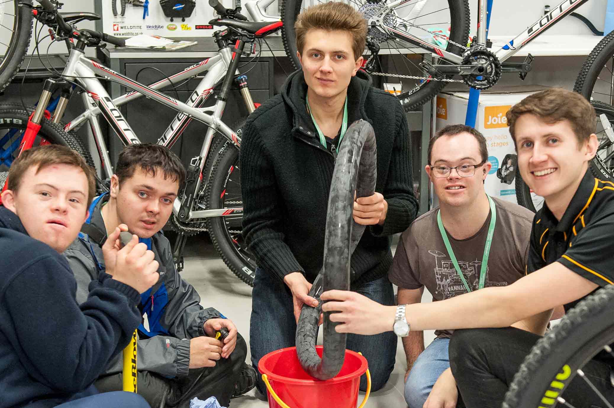 From left to right – Students Jake Vicars, Alex Lofthouse, Alex Guadagnino and Jacob Brown from Henshaws learn how to fix a puncture during a bike workshop with Adam Jones, Assistant Manager at Halfords on Knaresborough Road