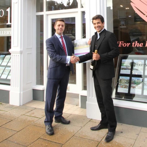 Richard Eccles, operations director, Community Partners presents the calendar and bottle of champagne to Daryll Digpal, managing director of Beadnall Copley, Harrogate