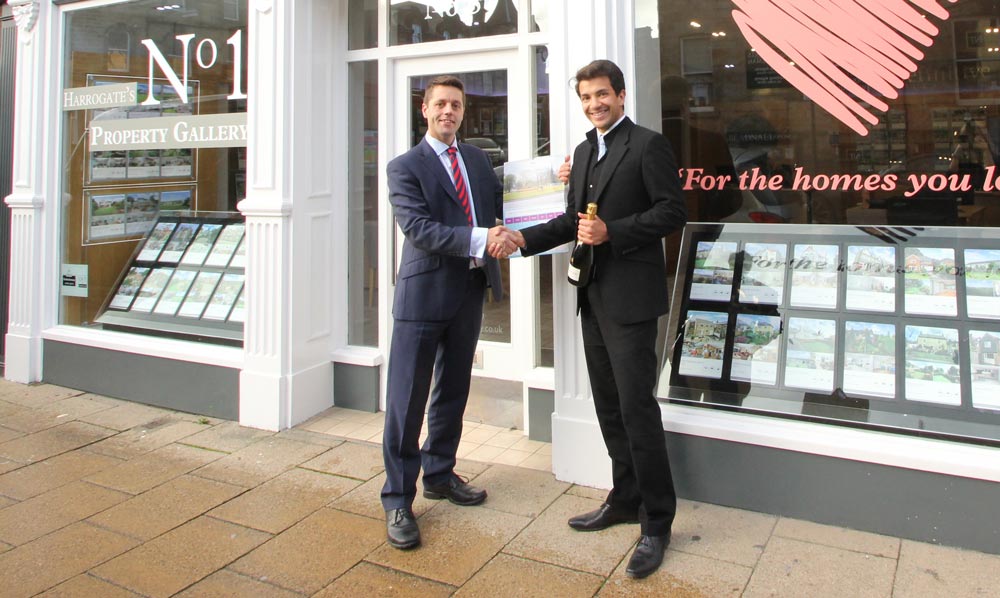 Richard Eccles, operations director, Community Partners presents the calendar and bottle of champagne to Daryll Digpal, managing director of Beadnall Copley, Harrogate