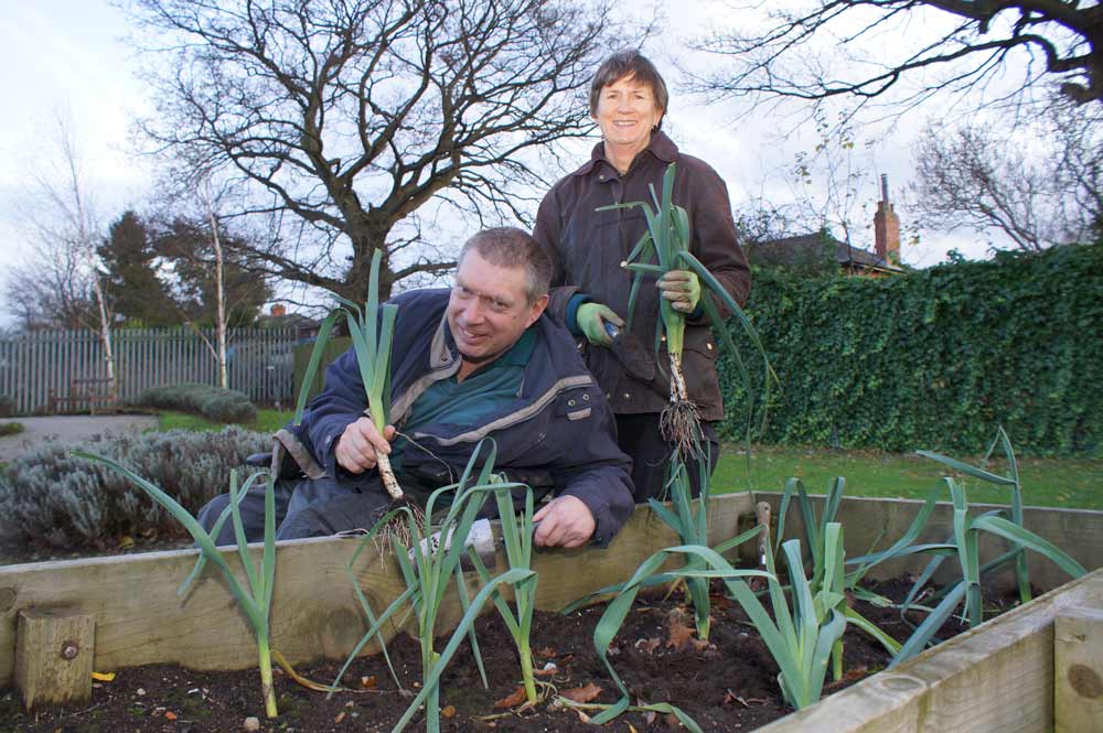 Green Fingered Support! Disability Action Yorkshire service user Wayne Martin helps volunteer Carolyn Rothwell harvest a bumper crop of leeks