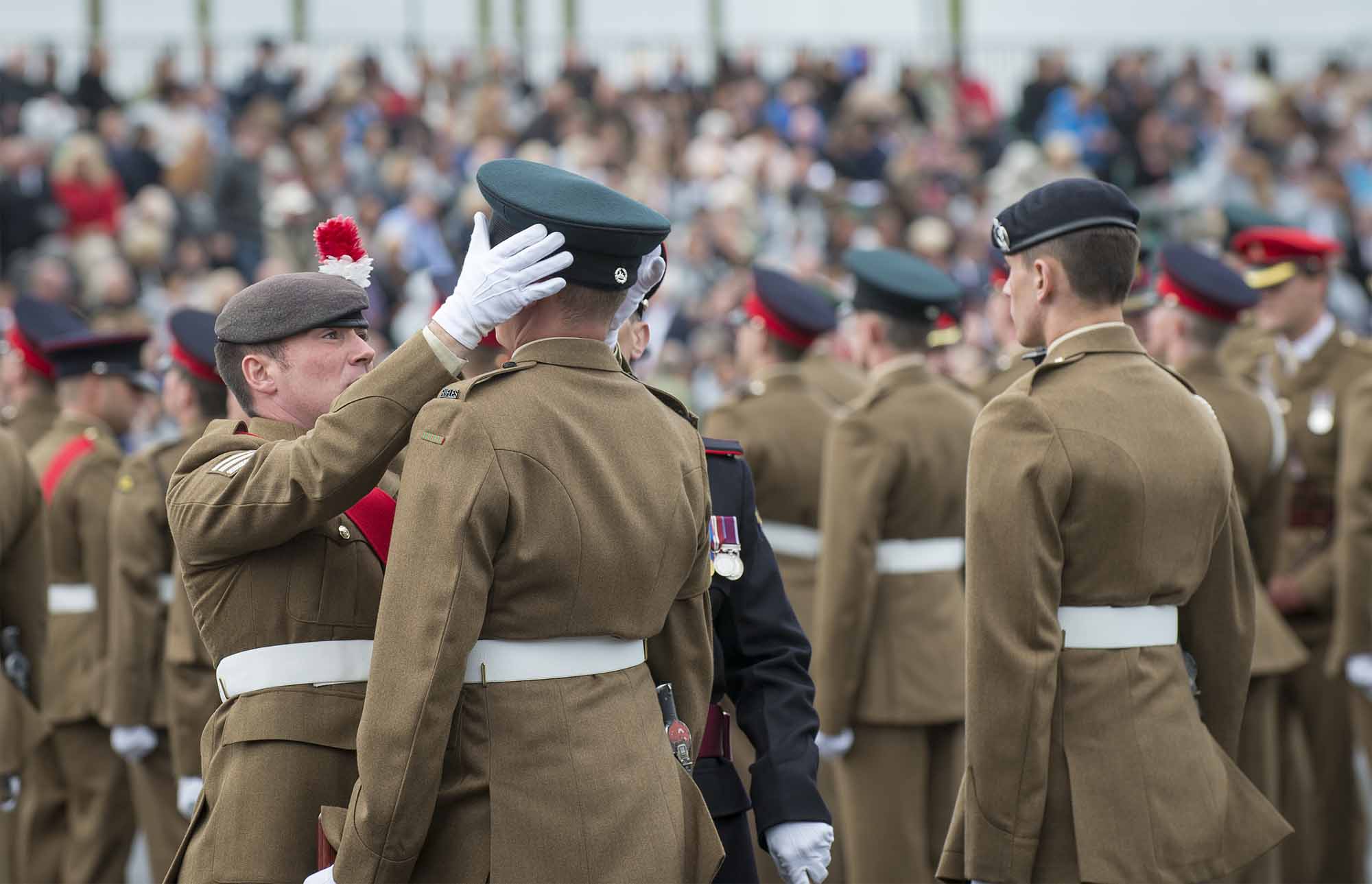 Pictured:One of the AFC instructors putting a Junior Soldier's hat back on after the strong wind blew it off. More than 600 teenagers from the Army Foundation College marched on their way to a new career when they graduated from the military training establishment in Harrogate, North Yorkshire. The college in Penny Pot Lane, Harrogate runs two types of course – a 40-week long course and a shorter 20-week course to train 16-17 year olds for a wide variety of Army careers. NOTE TO DESKS:  MoD release authorised handout images.  All images remain Crown Copyright 2016.  Photo credit to read -Sgt Jamie Peters RLC (Phot) Email: jamiepeters@mediaops.army.mod.uk richardwatt@mediaops.army.mod.uk shanewilkinson@mediaops.army.mod.uk Richard Watt - 07836 515306 Shane Wilkinson - 07901 590723