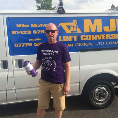 Mike McAvoy in his hospice T shirt with his collection tin