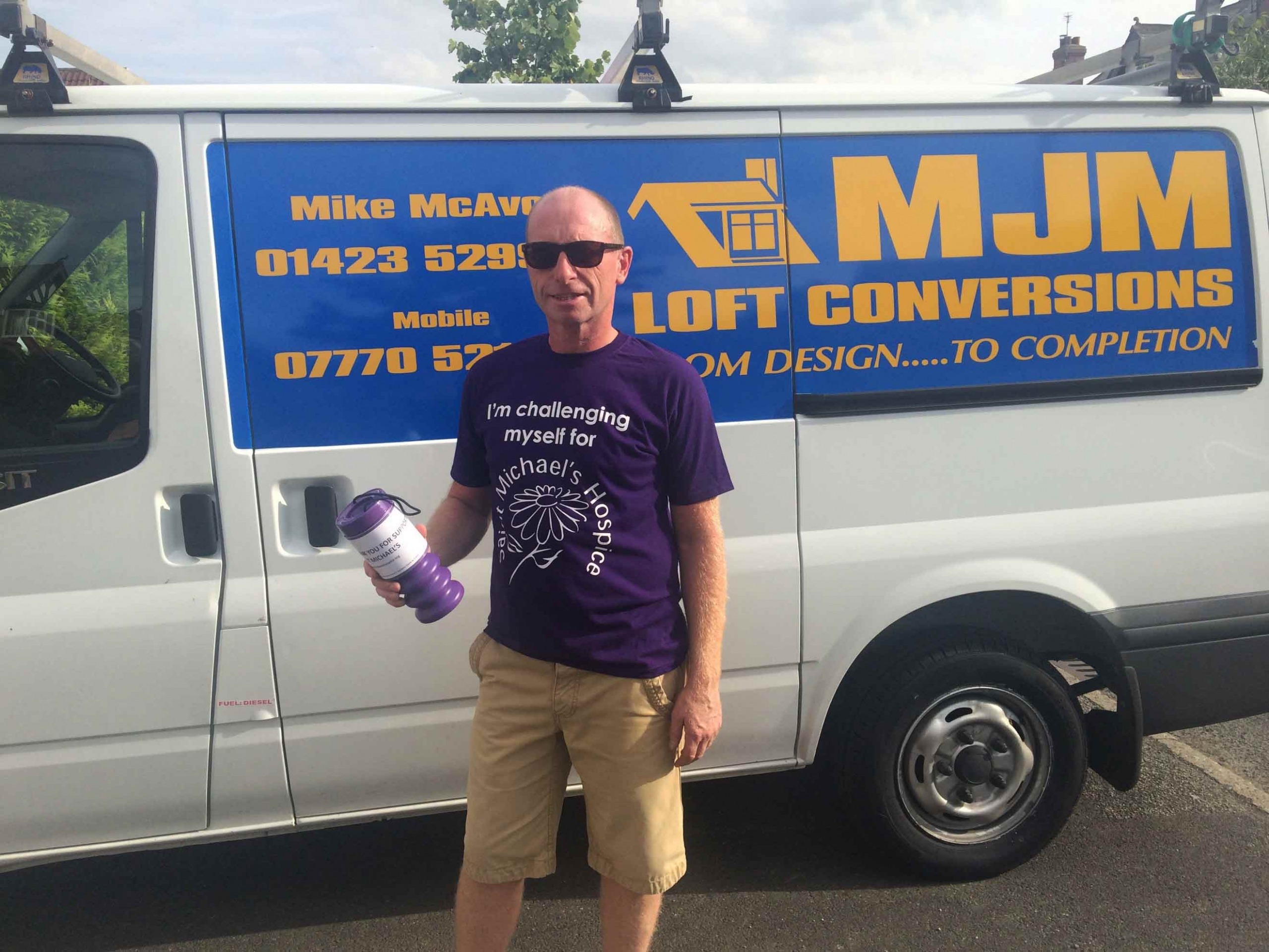 Mike McAvoy in his hospice T shirt with his collection tin