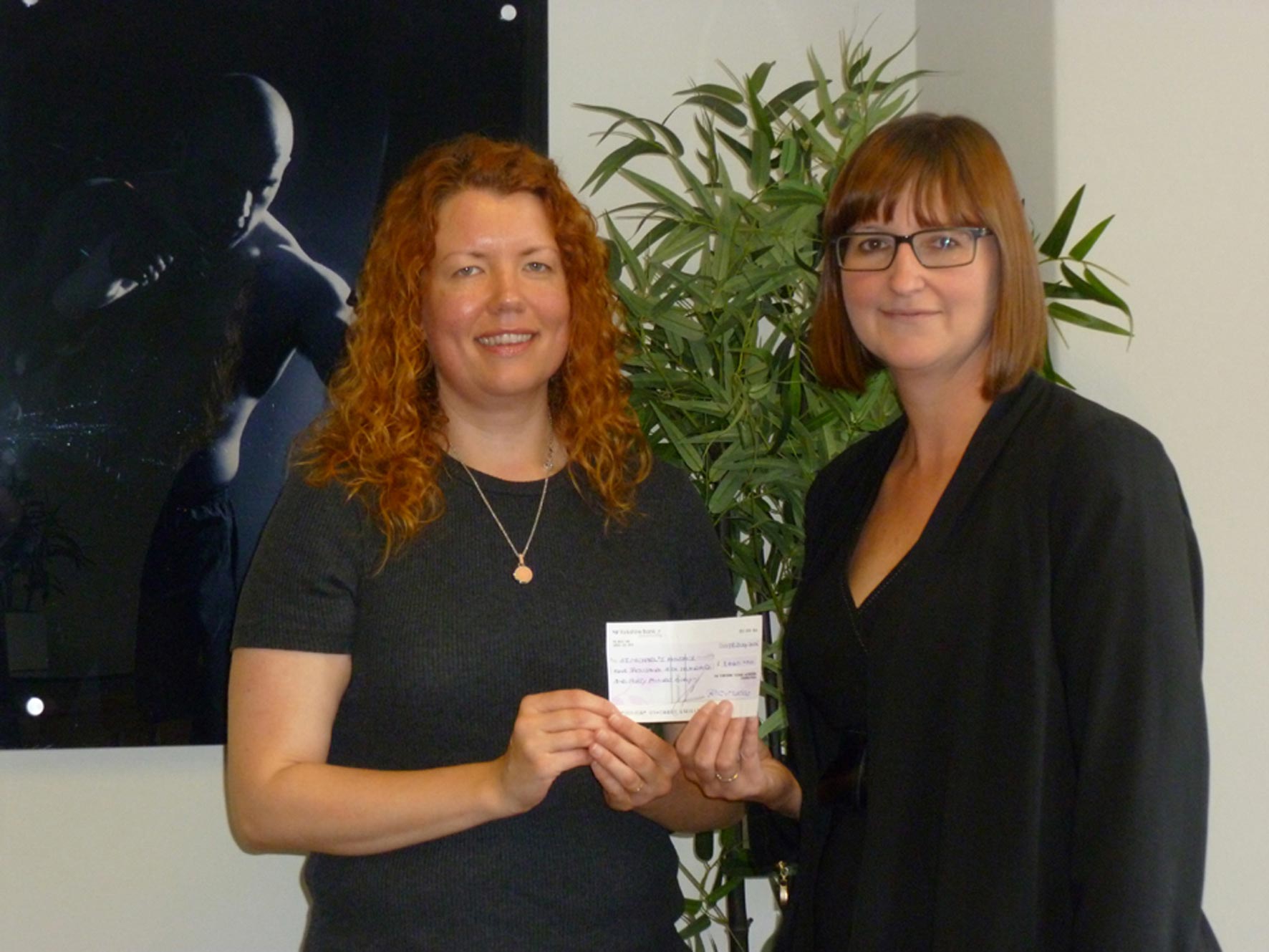 Megan Itson receives the cheque from Sonia Jones