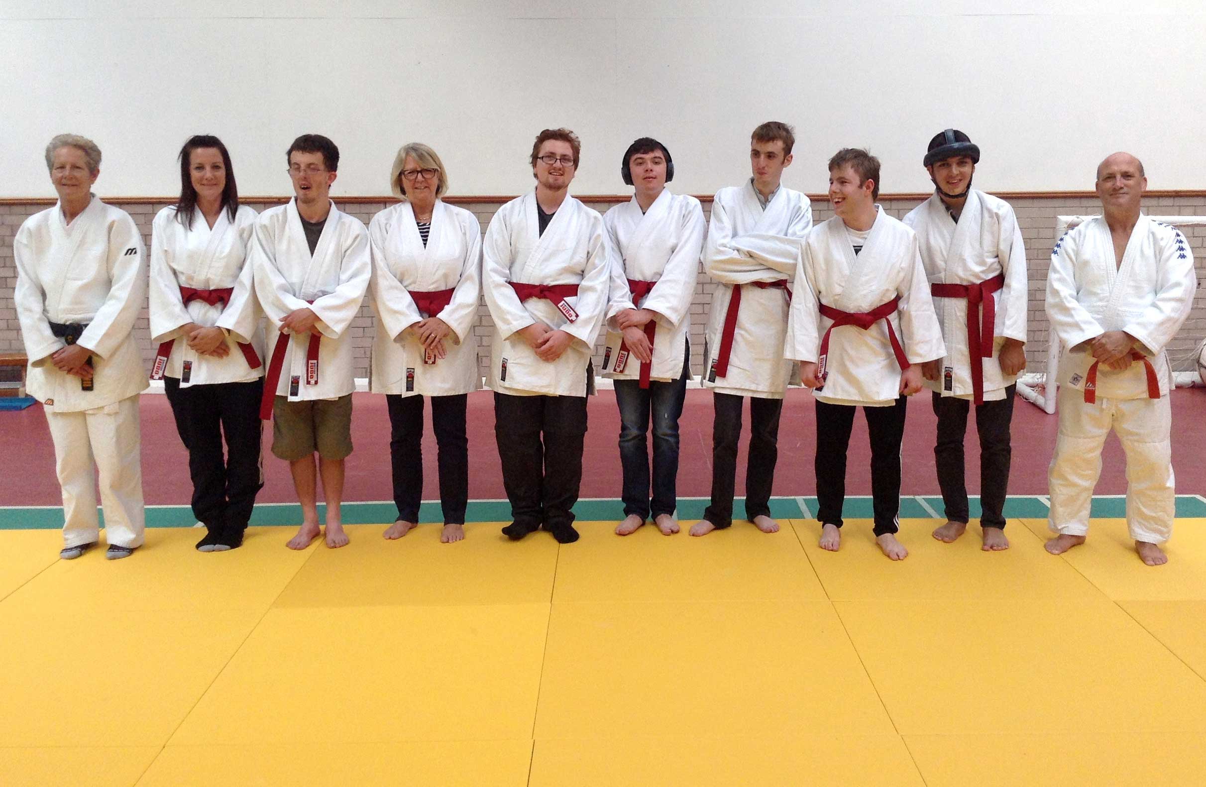 Henshaws Specialist College students celebrate achieving their red belts with staff and coaches