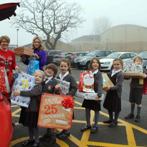 It’s A Wrap! Young Carers Hetty Flynn and Laura Winfield gratefully accept gifts from Ashville Pre-Prep School pupils
