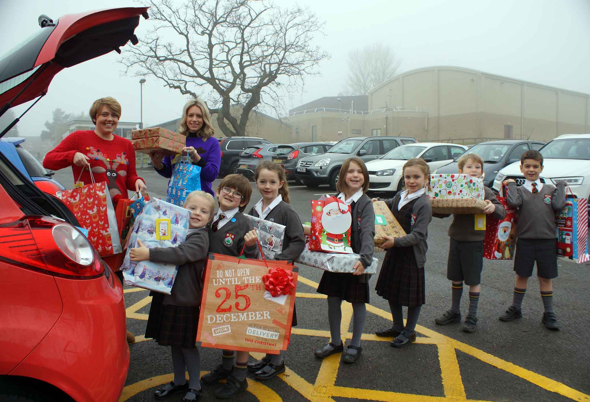 It’s A Wrap! Young Carers Hetty Flynn and Laura Winfield gratefully accept gifts from Ashville Pre-Prep School pupils