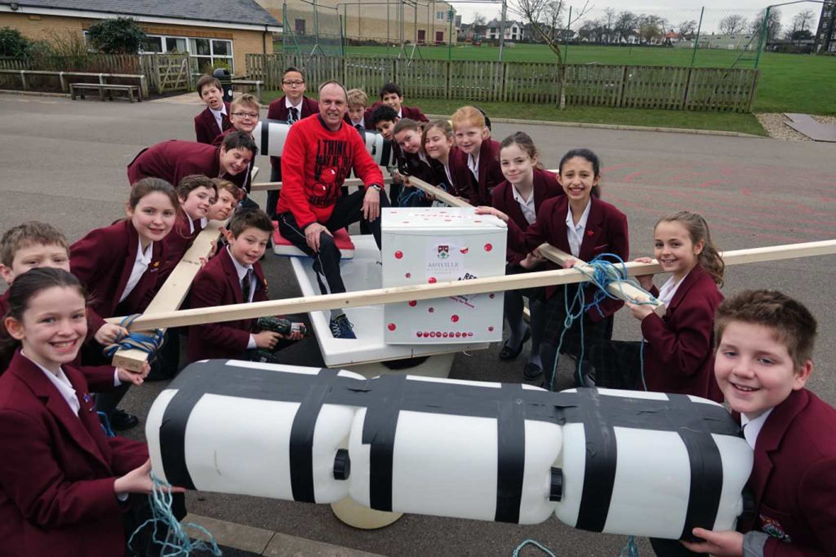 Water-borne Comedy Challenge. Ashville Junior School teacher Ian Dimmick is given a helping hand putting his bath raft together by his class