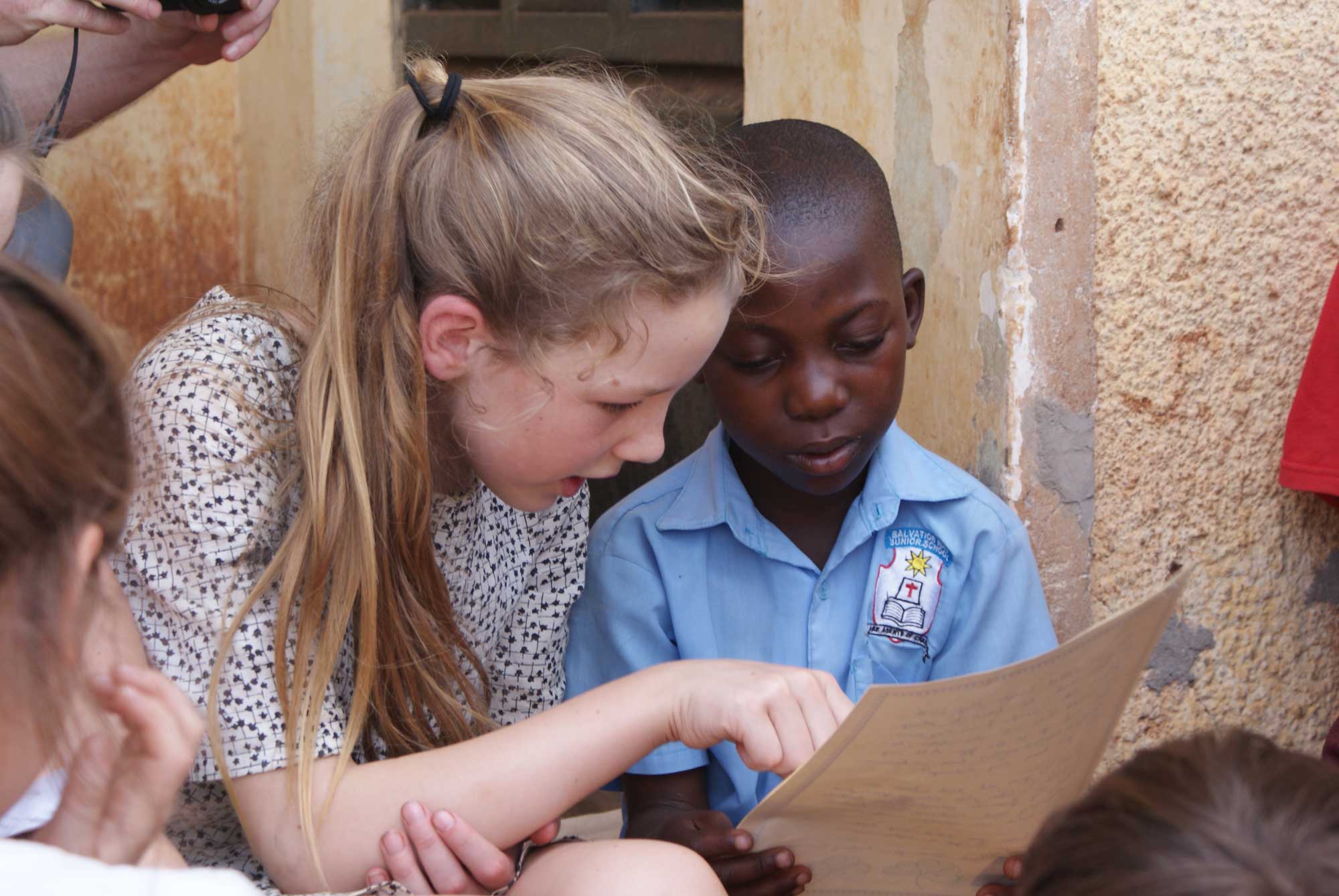 Highfield Prep School pupil reading with a pupil from Bombo village school in Uganda