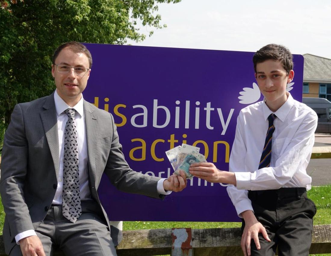 St Aidan’s Year 10 pupil Aidan Wheeler presents the proceeds of the cake bake to Disability Action Yorkshire’s Operation Manager David Ashton Jones