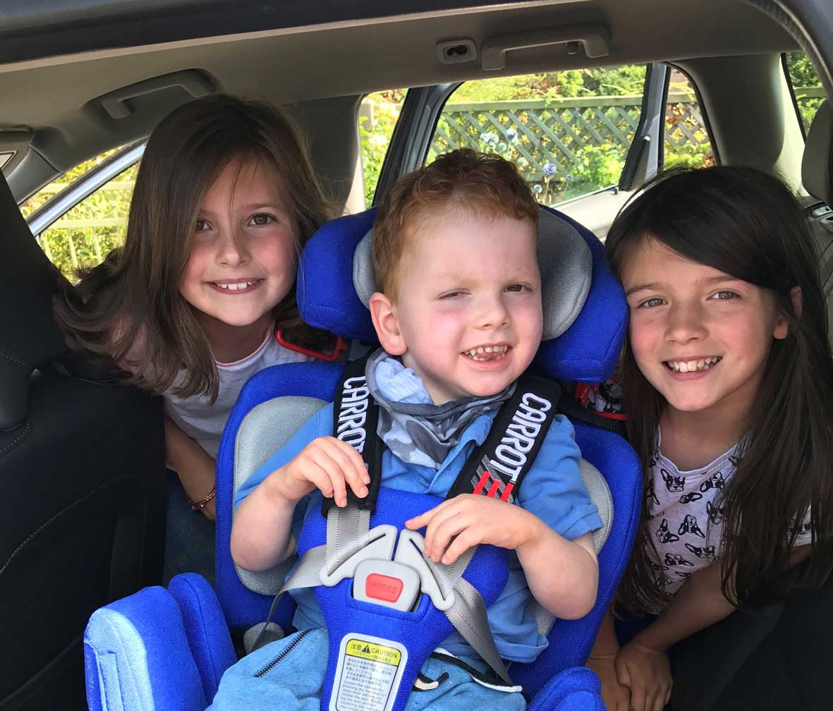 Felix in his new car seat with his big sisters, Kitty, left, and Amelie