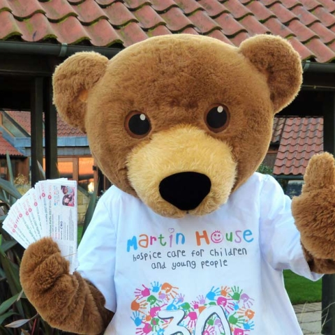 Martin House mascot Marty Bear with the Christmas raffle tickets
