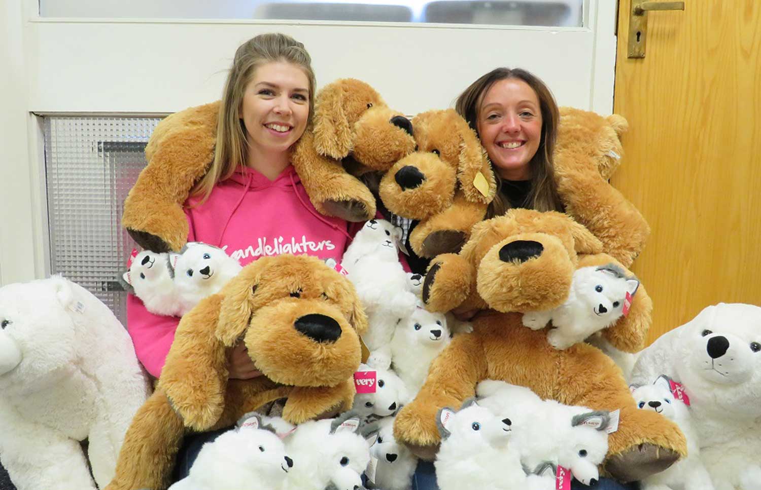 Fundraisers, Jen Aspinall and Gina Trotter, surrounded by cuddly toys looking for new homes