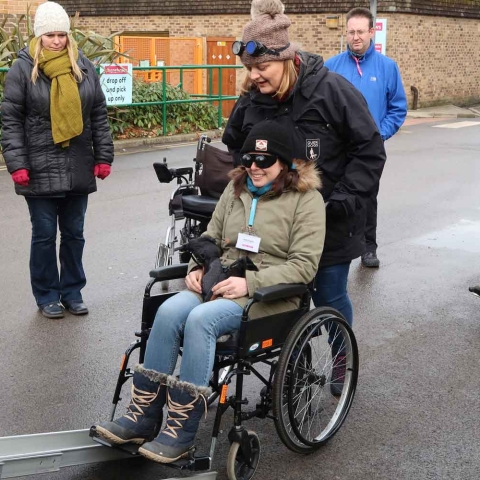 Guide Dogs mobility instructor Lucy Michaliszyn experiences the process of getting a manual wheelchair into a taxi, helped by Janet Kitching, children and young people habilitation specialist