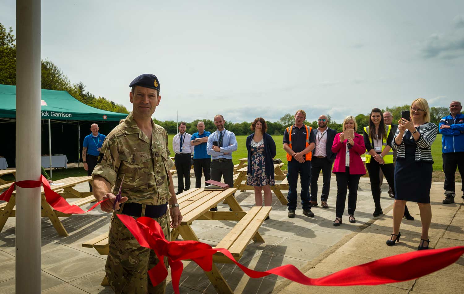 Lt. Gen. Tyrone Urch talking to staff at the new hockey pitch and cutting the ribbon of the newly refurbished pavilion at the Robertson Road sports complex