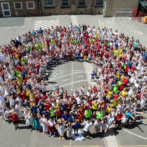 The whole of Western Primary School, pupils, staff, Headteacher and Chair of Governors depicting ‘O’ for Outstanding