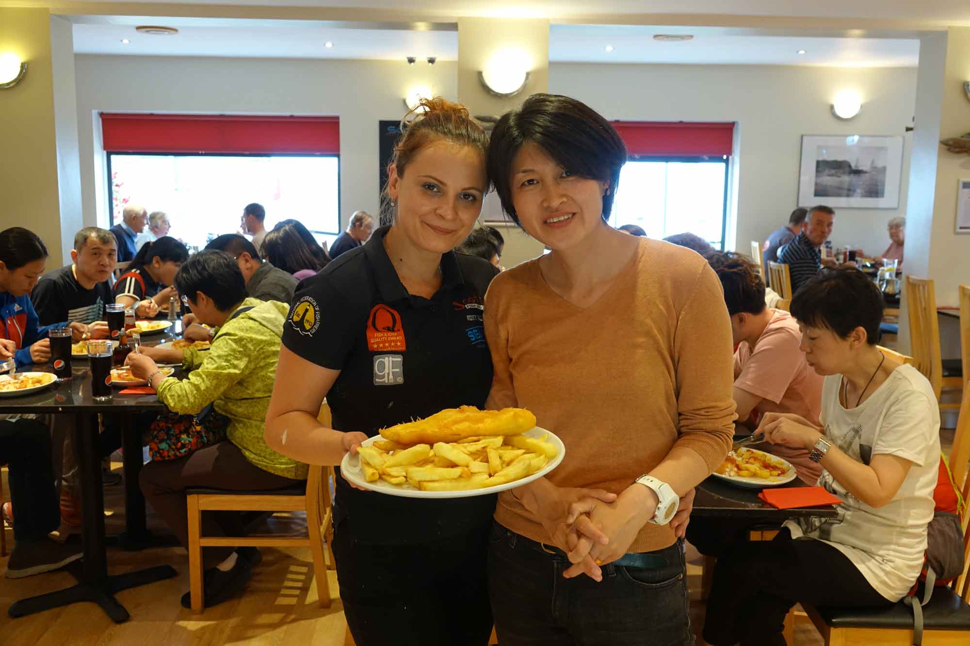 Caption: Fish and chips times 21! Scotts Fish and Chips manager Roxana Vasai (right) and Chinese tour group leader, Linda Lin in front of her tour group