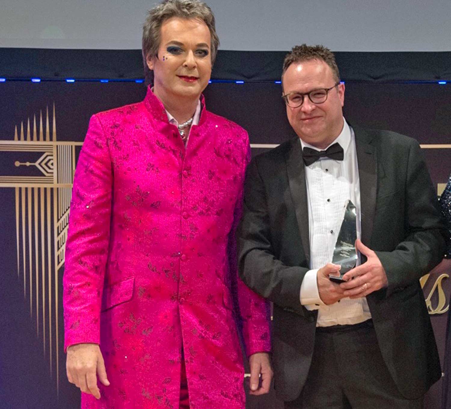 David Waddington, Land and New Homes Director at Linley & Simpson, picks up the Community Champion gold award on behalf of the agency from comic Julian Clary