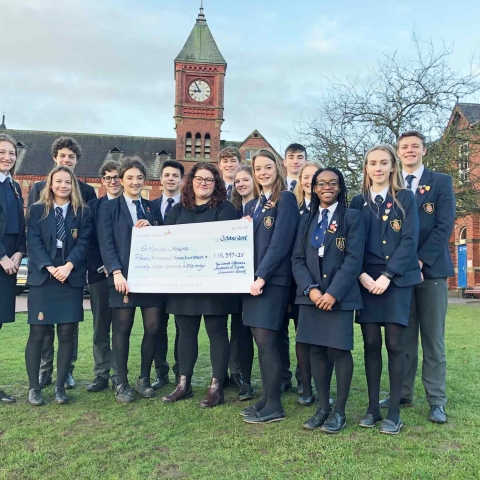 Record-breaking: Grace Withyman, left, and Louise Taylor, right, surrounded by their fellow students, present the £15,397 cheque to St Michael's Hospice fundraiser Beth Crewe