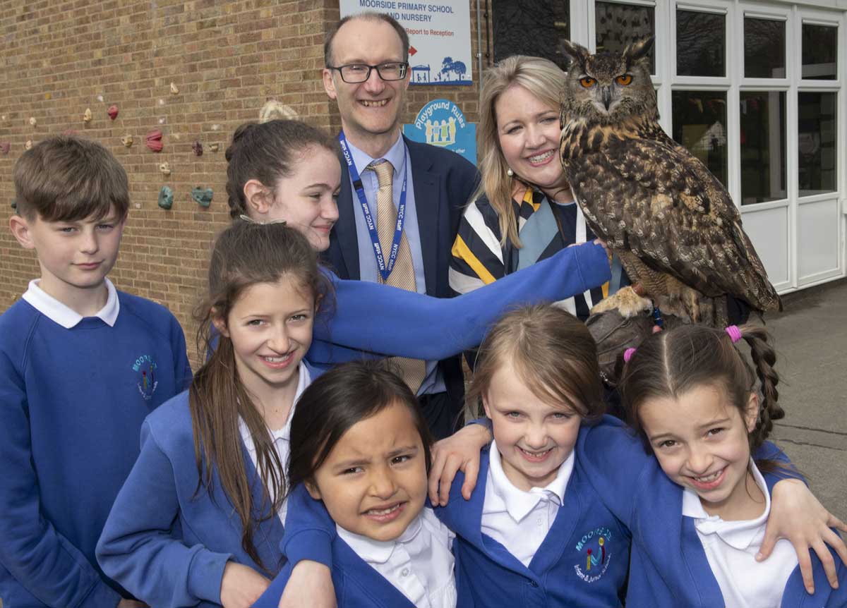 at the amalgamation celebration are John Lee, County Council strategic planning officer, and Claire Rowett, Moorside Primary School headteacher, with children from Years 3 to 6