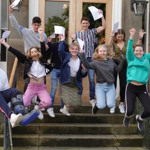 successful pupils jump for joy as they collect their A Level results