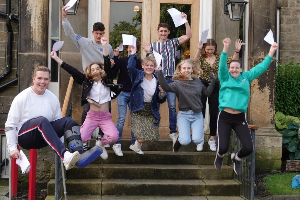 successful pupils jump for joy as they collect their A Level results