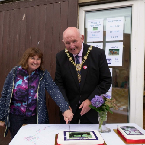 Victoria Thomas (Rider) with the Mayor of Harrogate, Cllr Stuart Martin, cutting the celebration cake