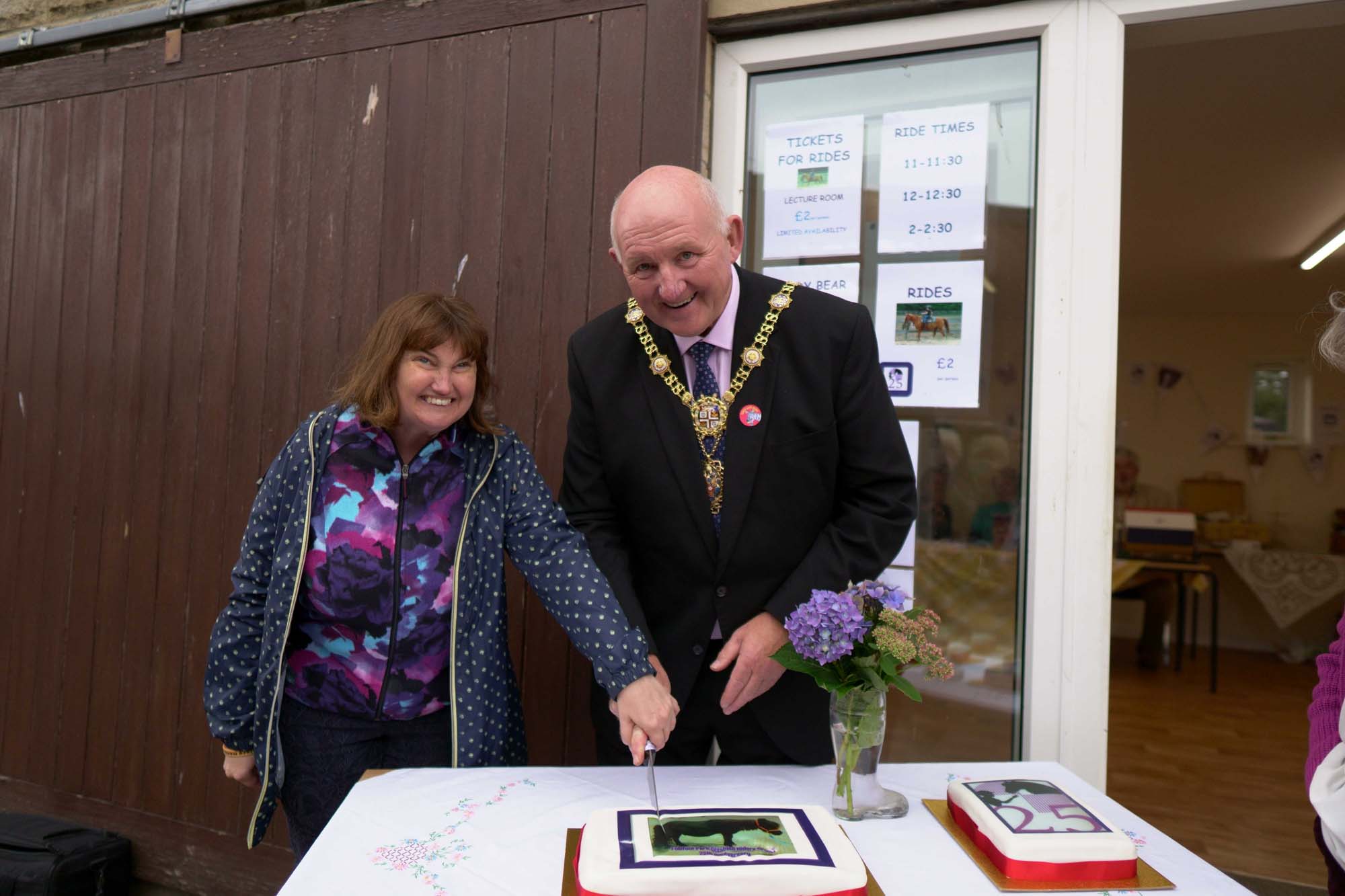 Victoria Thomas (Rider) with the Mayor of Harrogate, Cllr Stuart Martin, cutting the celebration cake