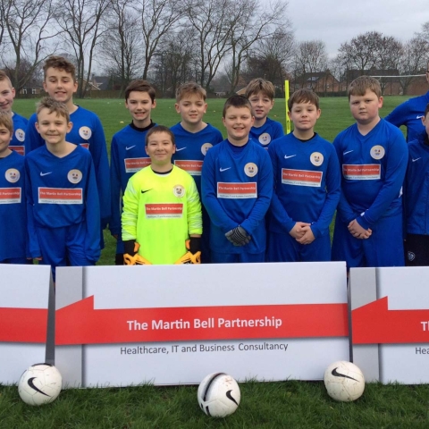 Boroughbridge Juniors FC Under 12s wearing their new kit sponsored by The Martin Bell Partnership, with team coach, Colin Fenny