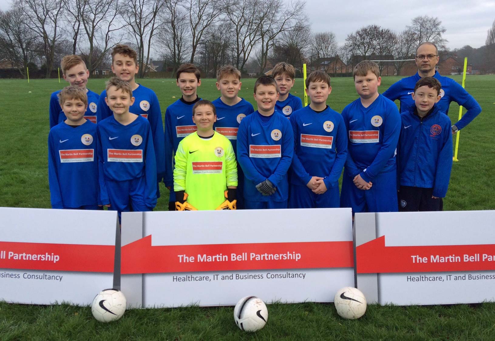 Boroughbridge Juniors FC Under 12s wearing their new kit sponsored by The Martin Bell Partnership, with team coach, Colin Fenny