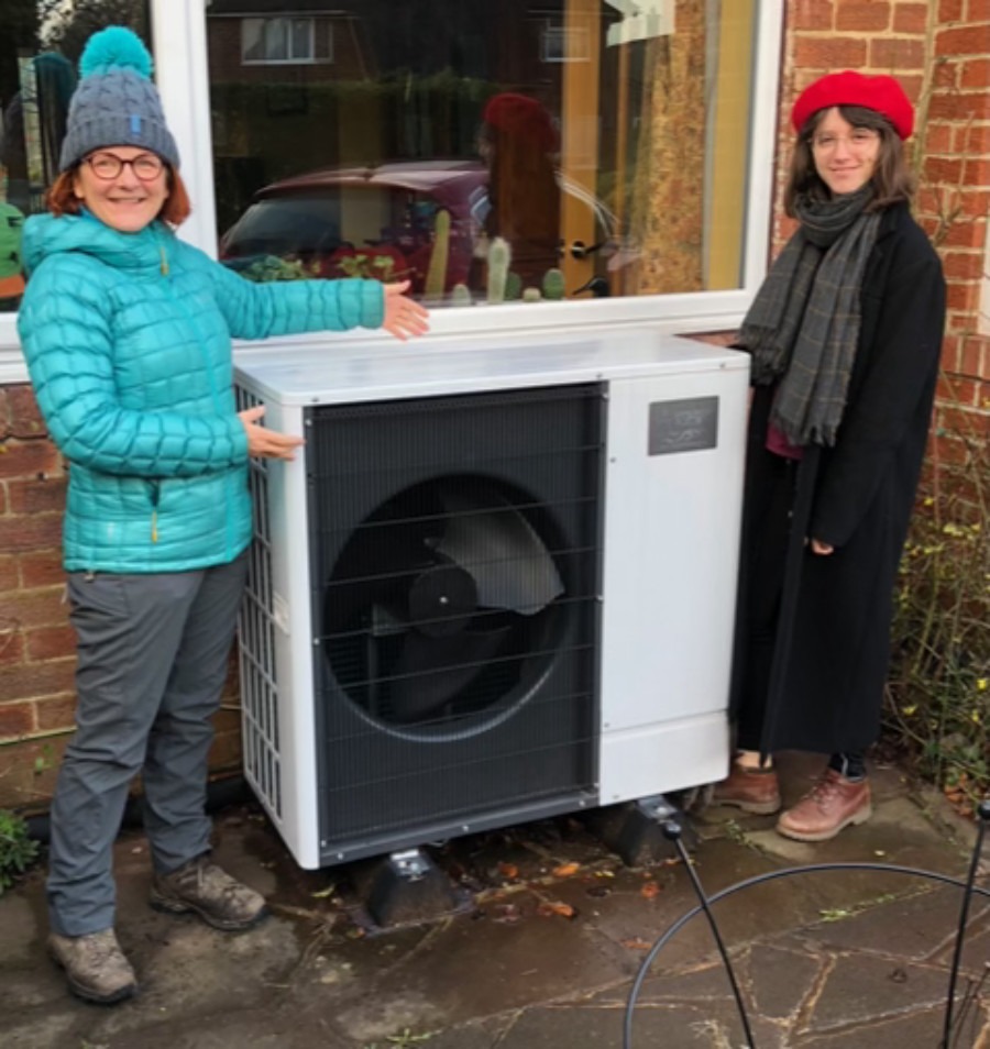 Kirsty Hallett (Chair of Harrogate District Climate Change Coalition Communications and Engagement Sub-group) demonstrating an air source heat pump (ASHP) which provides ample central heating and hot water for a local home. As burning fossil fuels in gas boilers is being legally phased out by the government, ASHPs will be used to heat most homes and many commercial spaces and hot water supplies using only renewable electricity.
