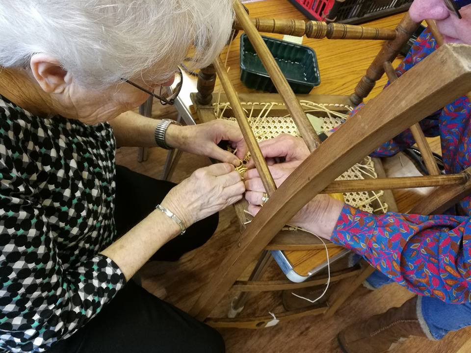 Members take part in a chair caning session