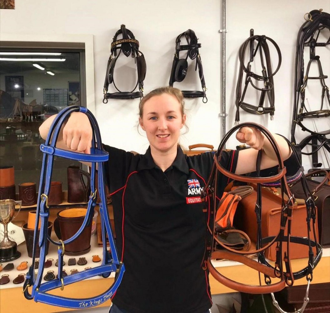 Lance Bombadier Farren holding handmade bridles in the saddlery