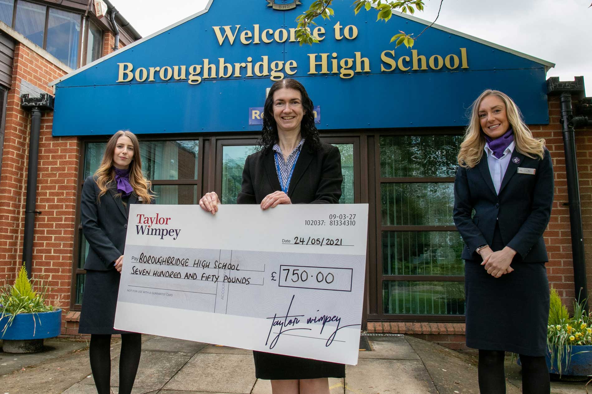 Headteacher-Kathryn-Stephenson-centre-with-Taylor-Wimpey-sales-executives-Victoria-Franks-left-with-Abby-Timmins-right