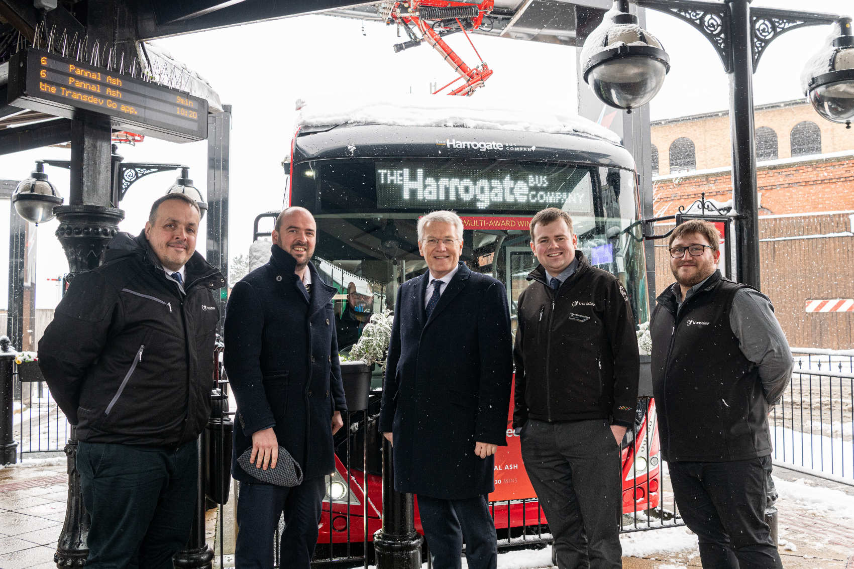 Buses Minister Richard Holden (second left) in wintry weather at Harrogate Bus Station with (from left) Transdev Operations Director Vitto Pizzuti; Harrogate and Knaresborough MP Andrew Jones; Transdev Commercial Manager Matt Burley; and Network Manager Alex Spencer
