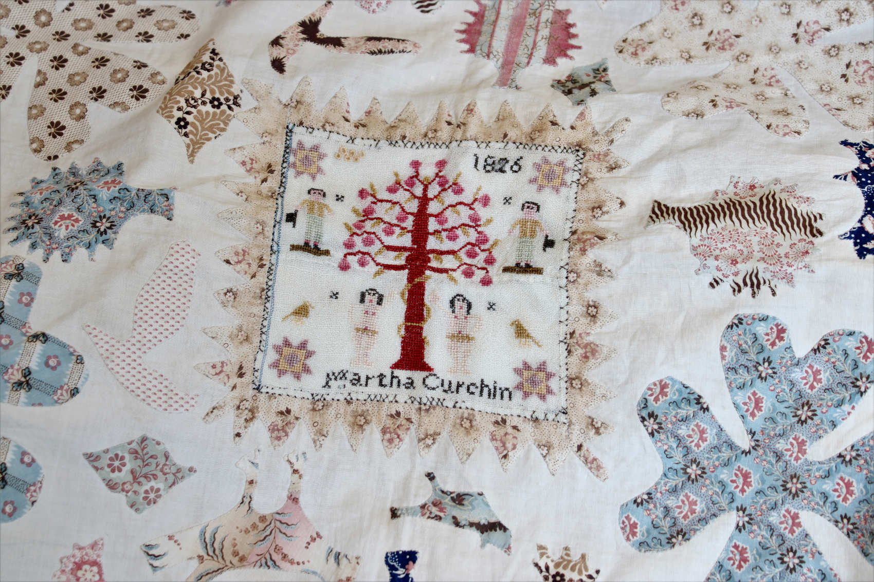 A Detail of an Unusual Early 19th Century Cotton Coverlet, centred with a sampler worked by Martha Curchin